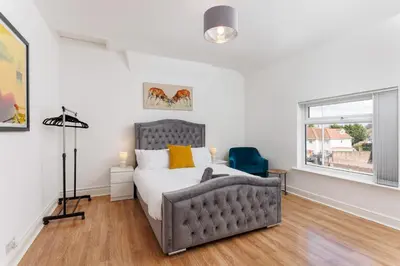 a bedroom with a bed and a window at Flatzy - Sleeps 16 Near Football Ground & Ping Pong Table in Liverpool