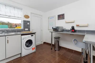 a kitchen with a washing machine and a sink at Flatzy - Sleeps 16 Near Football Ground & Ping Pong Table in Liverpool