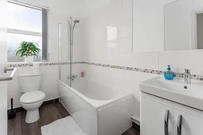 a white bathroom with a toilet and a sink at Flatzy - Sleeps 16 Near Football Ground & Ping Pong Table in Liverpool