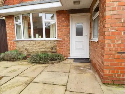 a white door on the side of a brick house at Jasmine Cottage in Lytham St Annes