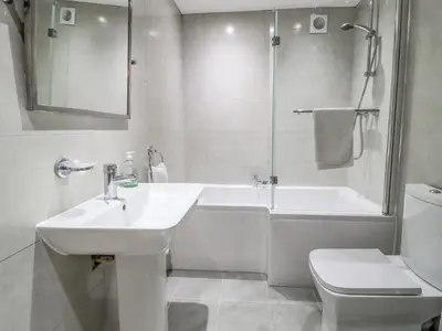 a bathroom with a sink and a tub and a toilet at Jasmine Cottage in Lytham St Annes