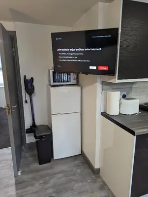 a kitchen with a white refrigerator and a microwave at Station Apartments in Ashton in Makerfield