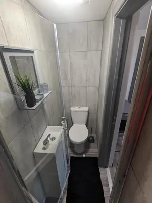 a small bathroom with a toilet and a sink at Station Apartments in Ashton in Makerfield