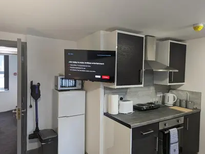 a kitchen with a refrigerator and a counter top at Station Apartments in Ashton in Makerfield