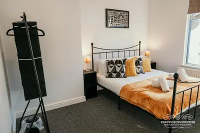 a bedroom with a bed with yellow pillows at Dover St by Prestige Properties SA in Barrow in Furness