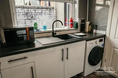 a kitchen with a sink and a microwave at Dover St by Prestige Properties SA in Barrow in Furness