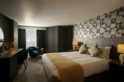 a hotel room with a bed and a desk at Park hall Hotel & Spa Lancashire, a member of Radisson Individuals in Eccleston