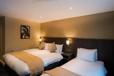 a hotel room with two beds and two lamps at Park hall Hotel & Spa Lancashire, a member of Radisson Individuals in Eccleston