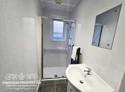 a white bathroom with a shower and a sink at Warwick St by Prestige Properties SA in Barrow in Furness