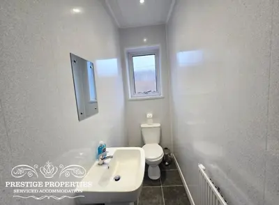 a white bathroom with a toilet and a sink at Warwick St by Prestige Properties SA in Barrow in Furness