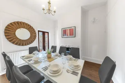 a dining room with a table with chairs and a mirror at Stylish Luxury Large 4BR KingBed in Barrow in Furness