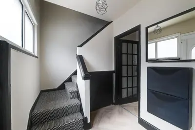 a staircase in a house with black and white walls at Poppy's Place - Manningham Road in Liverpool