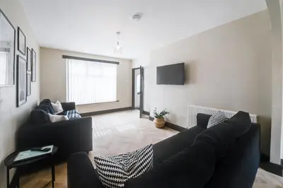 a living room with a couch and a tv at Poppy's Place - Manningham Road in Liverpool