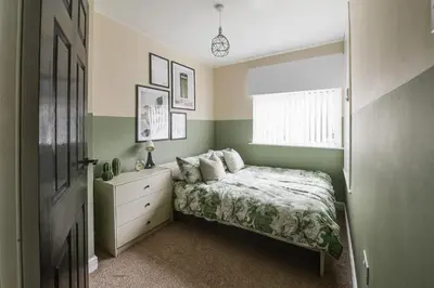 a bedroom with a bed and a dresser and a window at Poppy's Place - Manningham Road in Liverpool