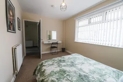a bedroom with a bed and a desk and a window at Poppy's Place - Manningham Road in Liverpool
