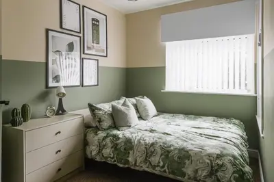 a bedroom with a bed and a dresser and a window at Poppy's Place - Manningham Road in Liverpool