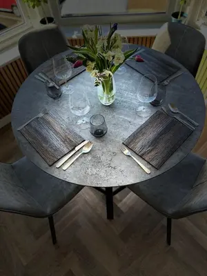 a round table with glasses and a vase of flowers at No 3 ,luxury 2 bed 1st floor apartment with free parking,Lytham St Annes in Saint Annes on the Sea