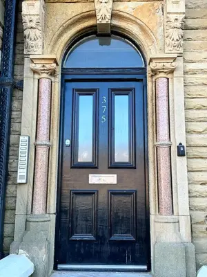 a black door of a building with a sign on it at No 3 ,luxury 2 bed 1st floor apartment with free parking,Lytham St Annes in Saint Annes on the Sea
