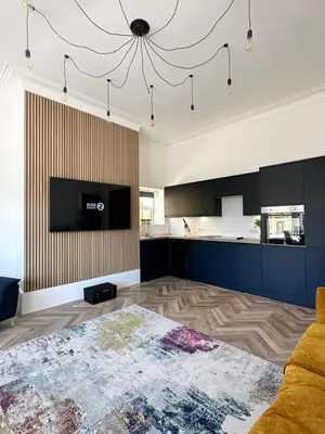 a living room with a couch and a tv and a kitchen at No 3 ,luxury 2 bed 1st floor apartment with free parking,Lytham St Annes in Saint Annes on the Sea
