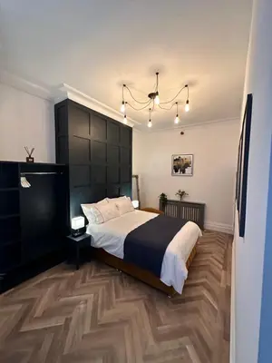 a bedroom with a large bed and a chandelier at No 3 ,luxury 2 bed 1st floor apartment with free parking,Lytham St Annes in Saint Annes on the Sea