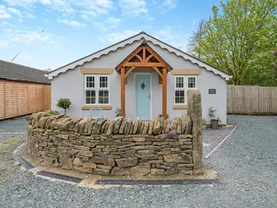 a small house with a stone wall in front of it at Briar Cottage in Great Eccleston
