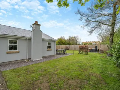 a backyard with a white house and a picnic table at Briar Cottage in Great Eccleston
