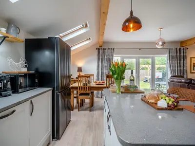 a kitchen with a black refrigerator and a dining room at Briar Cottage in Great Eccleston