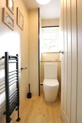a small bathroom with a toilet and a window at xxBrand Newxx sleeps 8, stylish japandi house in Blackpool