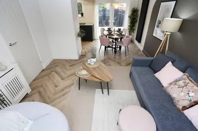 a living room with a blue couch and a table at xxBrand Newxx sleeps 8, stylish japandi house in Blackpool