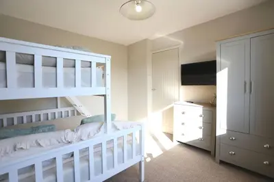 a white bedroom with a bunk bed and a dresser at xxBrand Newxx sleeps 8, stylish japandi house in Blackpool