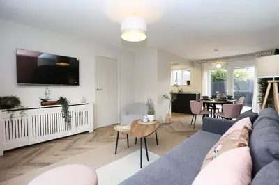 a living room with a blue couch and a table at xxBrand Newxx sleeps 8, stylish japandi house in Blackpool