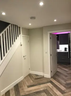 a hallway with a staircase and a room with wood floors at Modern 3 Bed Barn Conversion in Great Urswick in Great Urswick