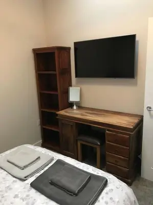 a bedroom with a desk and a tv on the wall at Modern 3 Bed Barn Conversion in Great Urswick in Great Urswick