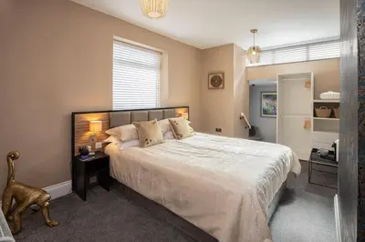 a bedroom with a large bed with a white bedspread at Coral Boutique Apartment 1 in Blackpool
