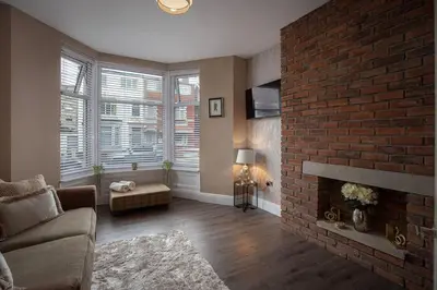 a living room with a brick fireplace and a couch at Coral Boutique Apartment 1 in Blackpool