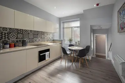 a kitchen with a table and chairs in a room at Coral Boutique Apartment 1 in Blackpool
