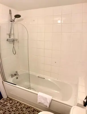 a bathroom with a bath tub and a toilet at The Comfy Flat- Modern & Bright 2 Bedrooms Apartment in Liverpool