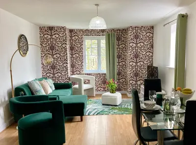 a living room with a green couch and a table at The Comfy Flat- Modern & Bright 2 Bedrooms Apartment in Liverpool