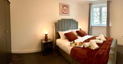 a bedroom with a bed with a tray of food on it at The Comfy Flat- Modern & Bright 2 Bedrooms Apartment in Liverpool
