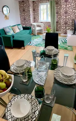 a living room with a table with plates and glasses at The Comfy Flat- Modern & Bright 2 Bedrooms Apartment in Liverpool