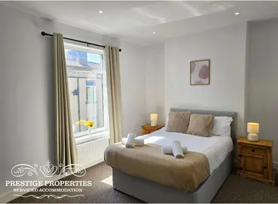 a bedroom with a large bed and a window at Manchester St by Prestige Properties SA in Barrow in Furness