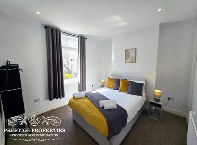 a bedroom with a large bed and a window at Manchester St by Prestige Properties SA in Barrow in Furness