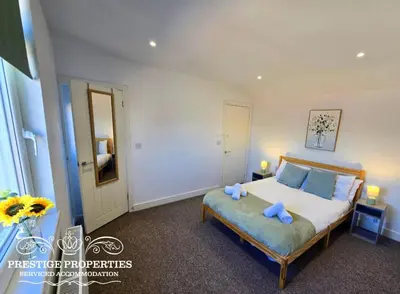 a bedroom with a bed with two blue towels on it at Manchester St by Prestige Properties SA in Barrow in Furness