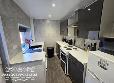 a kitchen with a sink and a stove top oven at Manchester St by Prestige Properties SA in Barrow in Furness