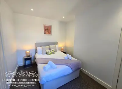 a bedroom with a large bed with blue pillows at Manchester St by Prestige Properties SA in Barrow in Furness