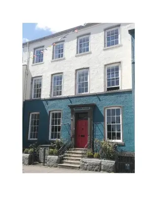 a white and blue building with a red door at Virginia House, Ulverston in Ulverston