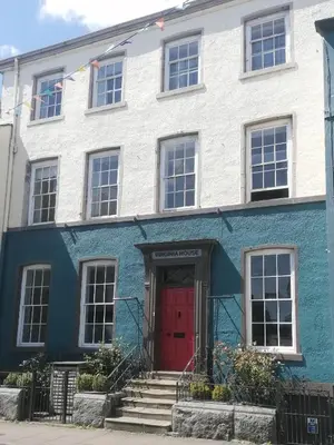 a blue and white building with a red door at Virginia House, Ulverston in Ulverston