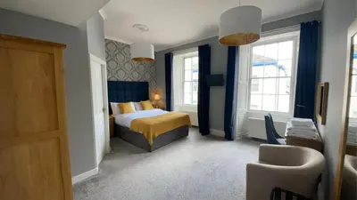 a hotel room with a bed and two windows at Virginia House, Ulverston in Ulverston