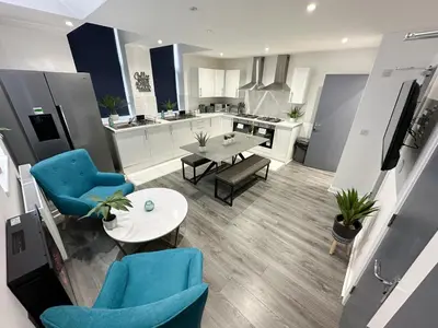 a kitchen and living room with blue chairs and a table at Regent Docks-Free Parking in Liverpool