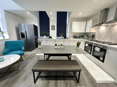 a large kitchen with a table and a blue chair at Regent Docks-Free Parking in Liverpool
